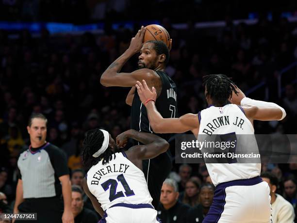 Kevin Durant of the Brooklyn Nets is double teamed by Patrick Beverley and Troy Brown Jr. #7 of the Los Angeles Lakers during the first half of the...