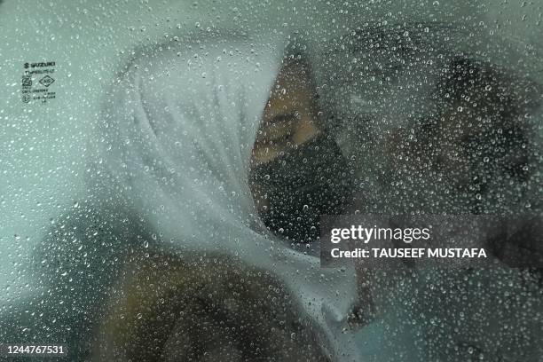 Girl sits inside a school van amid rainfall in Srinagar on November 14, 2022.