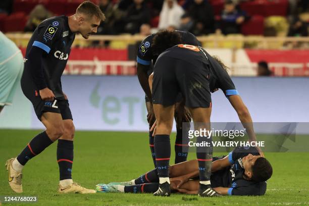 Marseille's Moroccan midfielder Amine Harit reacts in pain after suffering an injury during the French L1 football match between AS Monaco and...