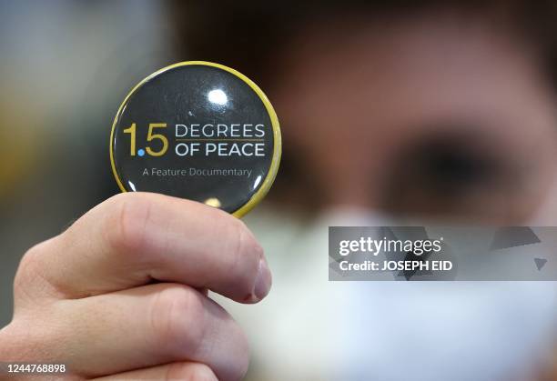 Button bearing the name of the documentary "1.5 Degrees of Peace" is pictured at the Sharm el-Sheikh International Convention Centre, in Egypt's Red...