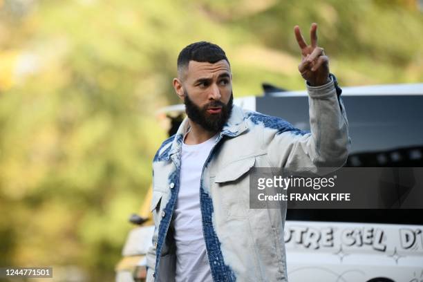 France's forward Karim Benzema flashes the sign of victory as he arrives for a get-together, two days before the French national team leave for the...