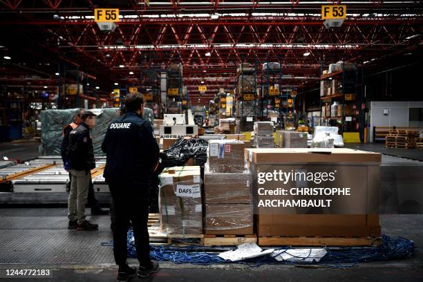 This picture taken on November 10, 2022 shows customs officials inspecting a pallet of airfreight at a warehouse at Roissy-Charles de Gaulle airport...