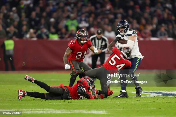 Antoine Winfield Jr. Of Tampa Bay Buccaneers, Mike Edwards of Tampa Bay Buccaneers, Lavonte David of Tampa Bay Buccaneers and Will Dissly of Seattle...