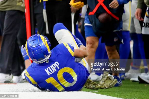 Los Angeles, CA Rams wide receiver Cooper Kupp rolls out of bounds holding his right leg after jumping to attempt to make a catch on a high throw...