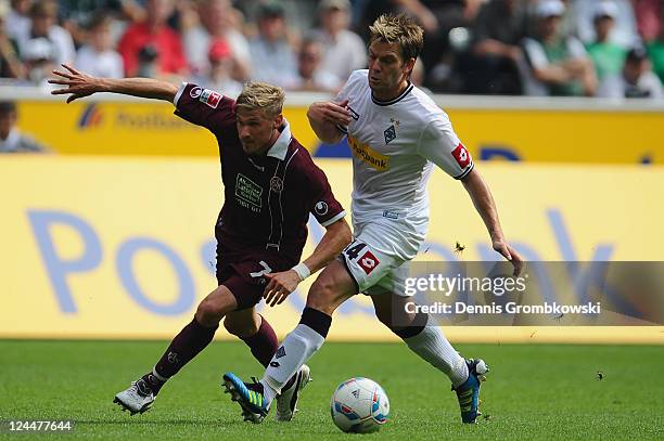 Oliver Kirch of Kaiserslautern and Thorben Marx of Moenchengladbach battle for the ball during the Bundesliga match between Borussia Moenchengladbach...