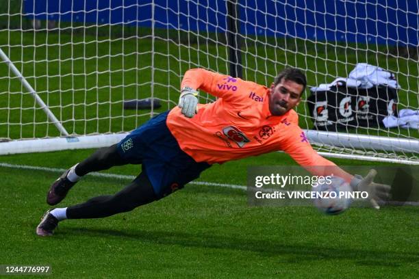 Brazil's goalkeeper Alisson deflects a shot during a training session on November 14, 2022 at the Continassa training ground in Turin, northern...