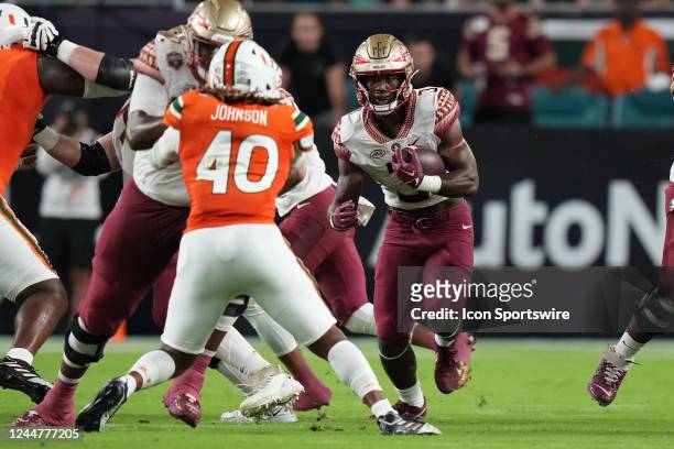 Florida State Seminoles running back Trey Benson looks for a hole as he rushes during the game between the Florida State Seminoles and the Miami...