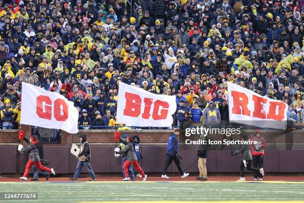 Nebraska cheerleaders run with large flags that spell out Go Big Red during a regular season Big Ten Conference college football game between the...