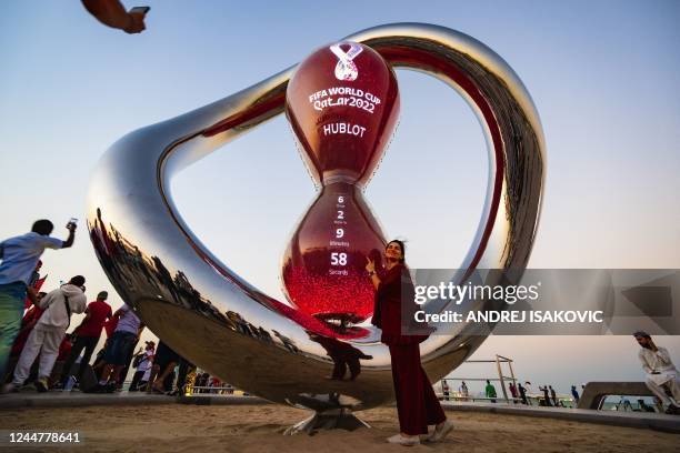 People gather for photos around the World Cup countdown clock in Doha on November 14 ahead of the Qatar 2022 World Cup football tournament.