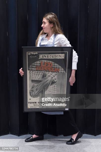 Staff member holds a rare UK 'In Person, Led Zeppelin' concert poster for Birmingham Town Hall signed by the band, 7th January 1970, estimate:...