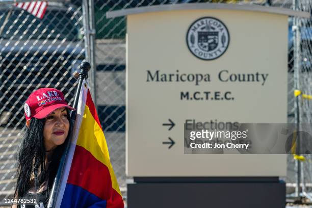 Right wing activist wearing a 'LAKE FOR GOVERNOR' hat stands on the sidewalk in protest of the election process in front of the Maricopa County...