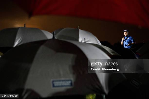 Attendees shelter under umbrellas as Muhyiddin Yassin, Malaysia's former prime minister and the leader of Perikatan Nasional party, speaks at a...