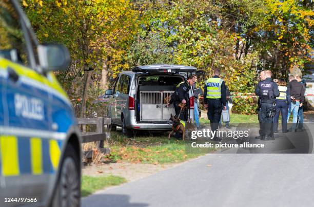 November 2022, North Rhine-Westphalia, Ostbevern: A police service dog handler walks from a vehicle with a Belgian shepherd dog to a small strip of...