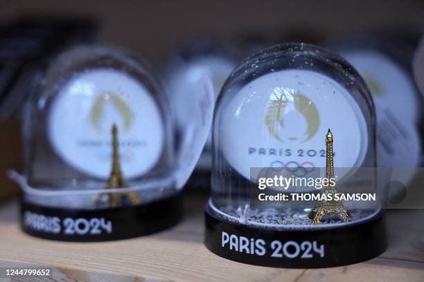 This photograph taken on November 15 in Paris, shows snow globes as part of official merchandising for the Paris 2024 Olympic and Paralympic Games,...