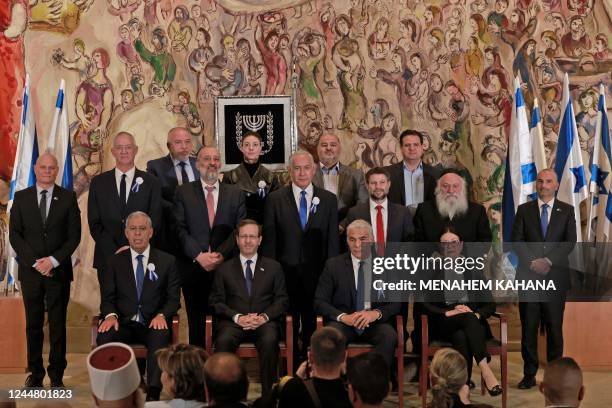 Israeli President Isaac Herzog sits in front of Israel's veteran ex-premier Benjamin Netanyahu and next to outgoing Prime Minister Yair Lapid as he...