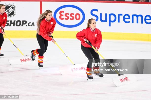 Calgary Flames ice girls clean the ice during the first period of an NHL game between the Calgary Flames and the Los Angeles Kings on November 14 at...