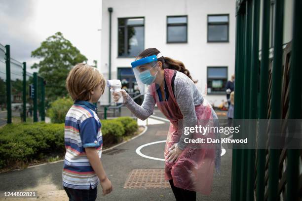 Member of staff wearing personal protective equipment takes a child's temperature at the Harris Academy's Shortland's school on June 04, 2020 in...