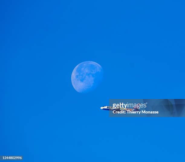 An Airbus A320 in Smurfs Livery from Brussels Airlines flying from Zaventem airport to Alicante pass beside the moon on November 12, 2022 in...
