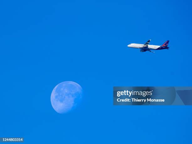 An Airbus A320 from Brussels AIrlines flying from Zaventem airport to Faro pass beside the moon on November 12, 2022 in Brussels, Belgium.
