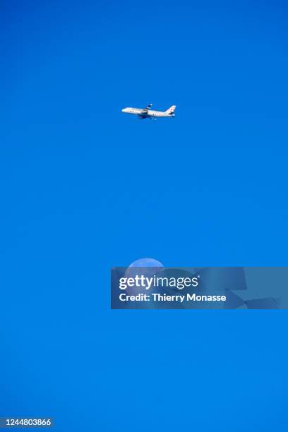 An Airbus A320 from Brussels Airlines flying from Zaventem airport to Malaga pass beside the moon on November 12, 2022 in Brussels, Belgium.