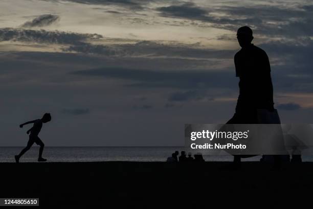 People walk in the sunset at Galle Face Beach on November 15, 2022 in Colombo, Sri Lanka