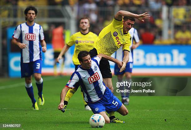 Robert Lewandowski of Dortmund and Andre Mijatovic of Berlin battle for the ball during the Bundesliga match between Borussia Dortmund and Hertha BSC...