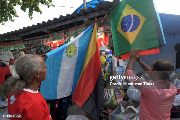 Jerseys of iconic football players like Messi, Neymar, Ronaldo and flags of Brazil, Argentina, and other nations on display for sale on at the...
