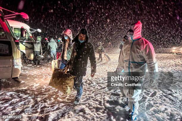 Police officers at a border police station escort stranded workers returning to their hometowns in Altay, Xinjiang province, China, Nov 15, 2022....