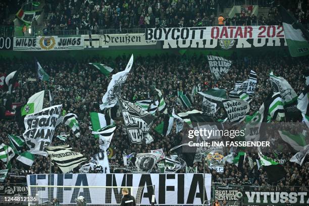 In this file photo taken on November 11, 2022 Fans display banners reading 'FIFA Mafia' and 'Boycott Qatar' during the German first division...