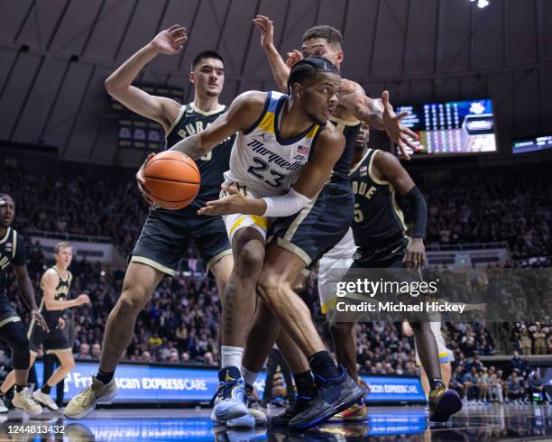 David Joplin of the Marquette Golden Eagles looks to pass the ball off under pressure from Mason Gillis of the Purdue Boilermakers during the first...