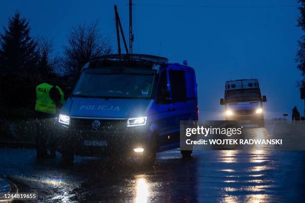 Police block a road on November 16, 2022 near the site where a missile strike killed two men in the eastern Poland village of Przewodow, near the...