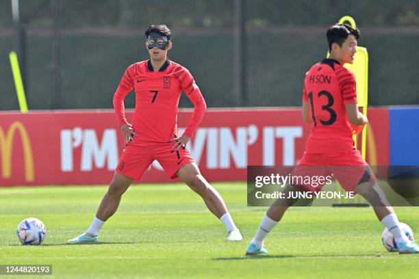 South Korea's Son Heung-min wearing a protective face mask takes part in a training session at Al Egla Training Site 5 in Doha on November 16 ahead...