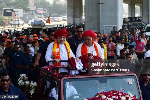 Gujarat State Chief Minister Bhupendrabhai Patel is accompanied atop a vehicle by Indian Home Minister Amit Shah during a rally before filing his...