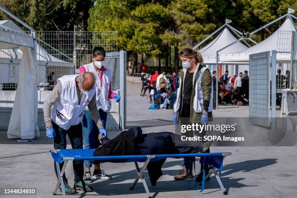 Members of Doctors Without Borders assist a woman lying on a camp bed. 263 migrants of different nationalities, arriving from Libya are rescued by...