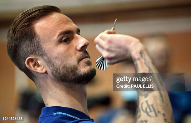 England's midfielder James Maddison takes on a journalist at darts during a media session at the Al Wakrah Stadium in Doha on November 16 ahead of...