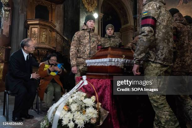 Tseng's mother seen holding the Ukrainian flag presented to her while the soldiers are about to carry Tseng's coffin. Ukraine organized a memorial...