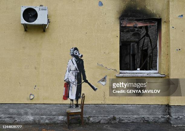 This photograph taken on November 16, 2022 shows a graffiti made by Banksy on the wall of a destroyed building in the town of Gostomel, near Kyiv,...
