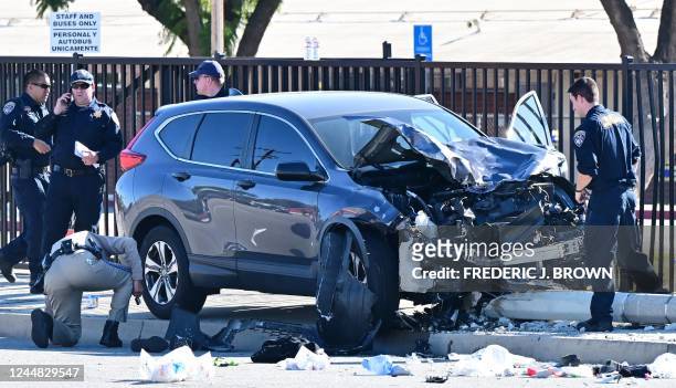 Law enforcement personnel take a closer look at the destruction of an SUV involved in critically injuring nearly two dozen deputy recruits in a Los...