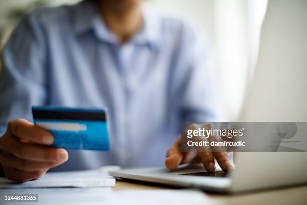 vrouw die online met behulp van laptopcomputer en creditcard winkelt - afslag stockfoto's en -beelden