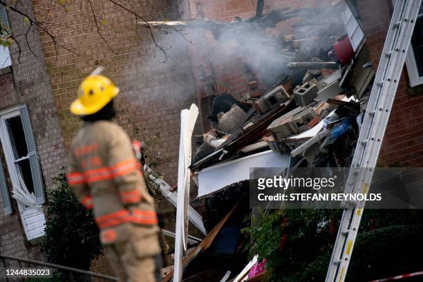 Firefighter looks at the site of a fire caused by an explosion at an apartment building in which 12 people were reported injured, according to...