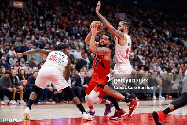 Fred VanVleet of the Toronto Raptors drives to the net between Jimmy Butler and Caleb Martin of the Miami Heat during the second half of their NBA...