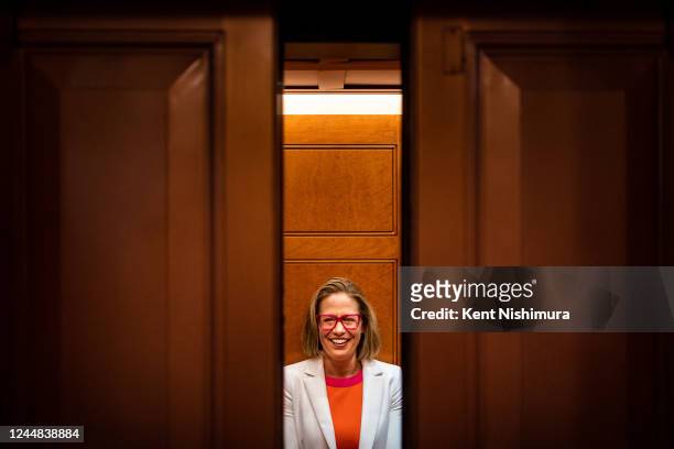 Sen. Kyrsten Sinema smiles while talking to reporters after leaving the Senate chamber following a procedural vote on federal legislation protecting...