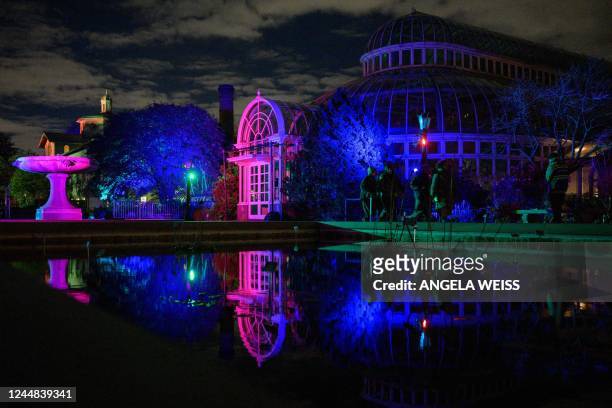 People walk around the holiday decoration exhibits during the Brooklyn Botanic Gardens Lightscape exhibition in New York City on November 16, 2022. -...