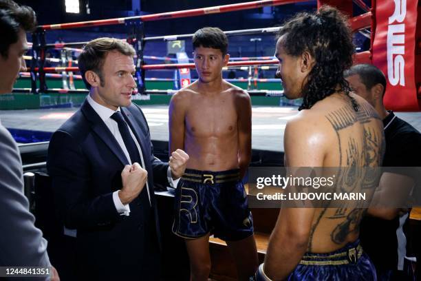 France's President Emmanuel Macron speaks with Muay Thai fighters during a visit to Rajadamnern Muay Thai Stadium in Bangkok on November 17 as he...