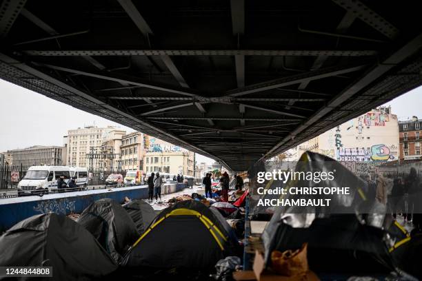 Migrants wait to embark buses for temporary shelter during the evacuation of their makeshift camp gathering hundreds, mostly Afghan, in Paris on...