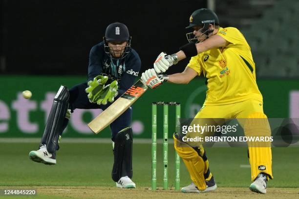 Australia's Steve Smith plays a shot watched by England's Jos Buttler during the first one-day international cricket match between Australia and...