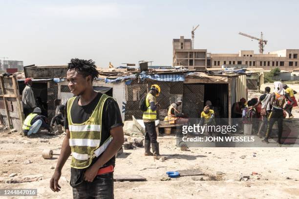 Construction workers rest during their lunch break in Diamniadio on November 16, 2022. - With the large demand from labour in Diamniadio,...