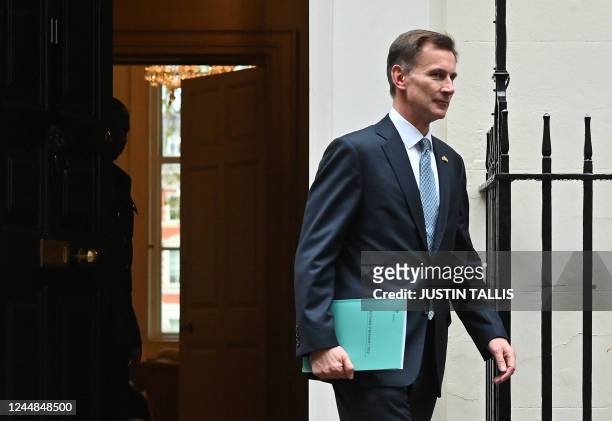 Britain's Chancellor of the Exchequer Jeremy Hunt walks out of Number 11 Downing Street in central London on his way to make a full budget statement...