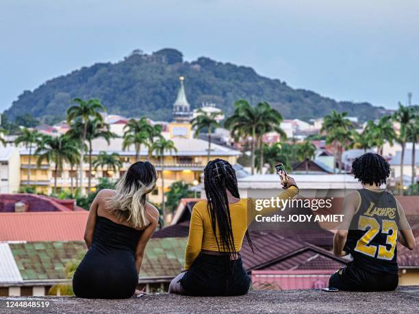 This photograph taken on October 15, 2022 shows bystanders taking a selfie at the Ceperou fort in Cayenne, French Guiana.