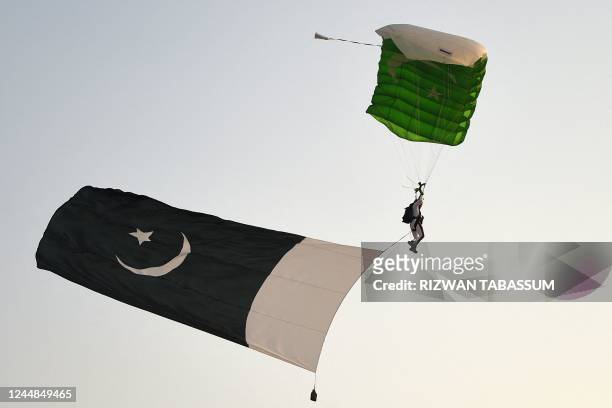 Pakistani military paratrooper takes part in a drill during the International Defence Exhibition and Seminar 2022 at the beach in Karachi on November...